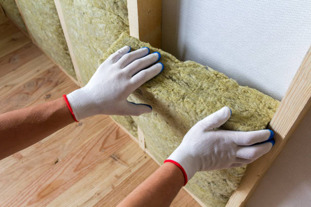 Close-up of worker hands in white gloves insulating rock wool insulation staff in wooden frame for future walls for cold barrier. Comfortable warm home, economy, construction and renovation concept. stock photo