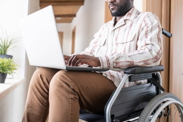 Close-up of young man with disability working in the net in home office stock photo