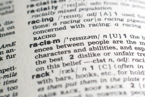A close-up on a word Racism in English dictionary (selective focus) A close-up on a particular word in English dictionary (selective focus). A good illustration for an article on topic. racism stock pictures, royalty-free photos & images