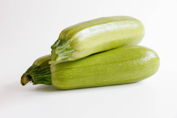Close-up on three whole green zucchini with stem on white background stock photo