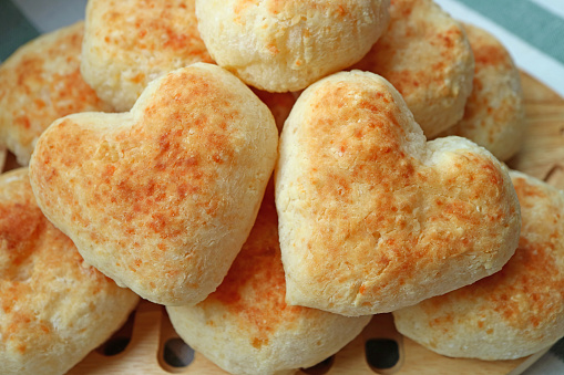 Closeup Pair of Delectable Heart Shaped Fresh Baked Pao de Queijo or Brazilian Cheese Breads on the Pile
