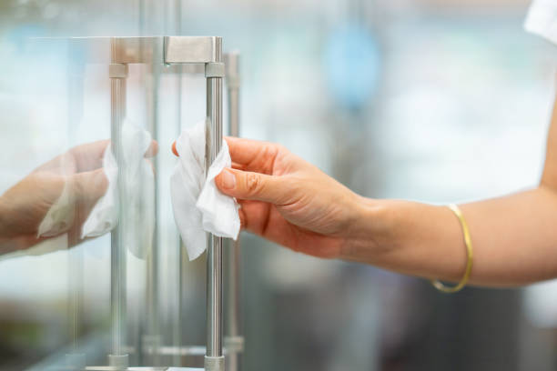 foto de close-up da mão da mulher ao desinfetar maçaneta de geladeira em supermercado antes de abrir porta - manivela objeto manufaturado - fotografias e filmes do acervo