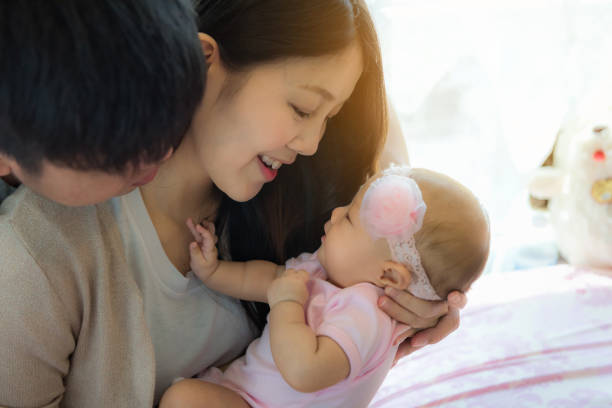 Close-up portrait of happy family with little baby on the bed stock photo