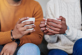 istock Closeup shot of an unrecognisable couple drinking coffee while relaxing together at home 1340768665