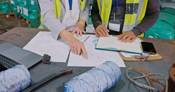 Closeup shot of an unrecognisable man and woman going through paperwork while working in a warehouse stock photo