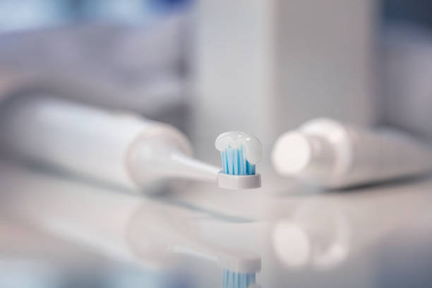 Closeup shot of electronic toothbrush with toothpaste stock photo