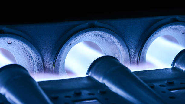 Closeup Shot Of Home Furnace Burner Ignited Closeup Shot Of Home Furnace Burner Ignited With Crimson Blue Flame furnace stock pictures, royalty-free photos & images