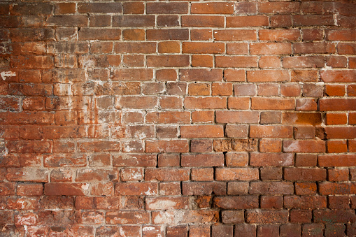 A close-up shot of the old rough brick masonry wall lined with red clumsy brick for creativity, textures and background.