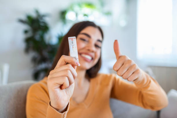 Close-up shot of woman's hand holding a negative test device. Happy young woman showing her negative Coronavirus - Covid-19 rapid test. Focus is on the test.Coronavirus stock photo