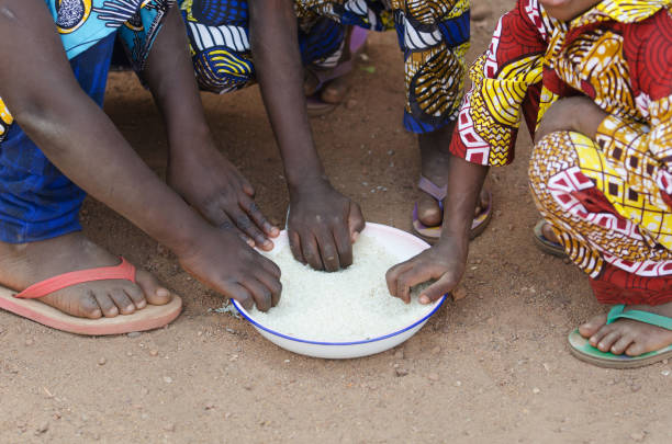 Close-Up Shot of Young African Boys and Girls Eating Outdoors stock photo