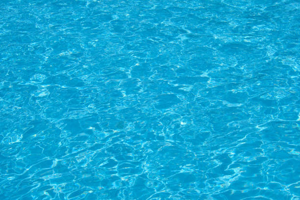 Closeup surface of blue clear water with small ripple waves in swimming pool. stock photo