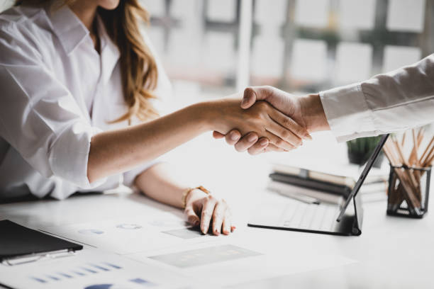 Close-up two business men holding hands, Two businessmen are agreeing on business together and shaking hands after a successful negotiation. Handshaking is a Western greeting or congratulation. stock photo