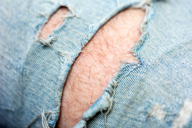 Closeup young man jeans with holes, background with copy space Closeup young man jeans with holes, background with copy space, full frame horizontal composition macro body hair stock pictures, royalty-free photos & images