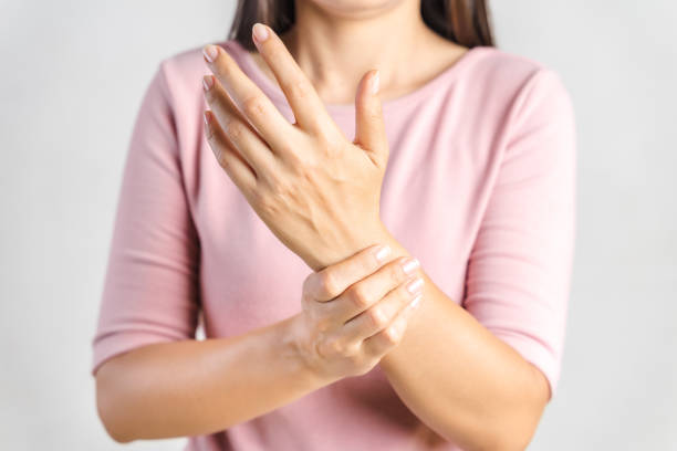 Closeup young woman holds her wrist on white background. hand injury, feeling pain. Health care and medical concept. Closeup young woman holds her wrist on white background. hand injury, feeling pain. Health care and medical concept. cramp photos stock pictures, royalty-free photos & images