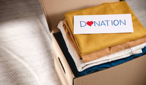 Clothes Donation Concept. Box of Cloth with Donate label. Preparing Used Old Garment at Home. Top View stock photo