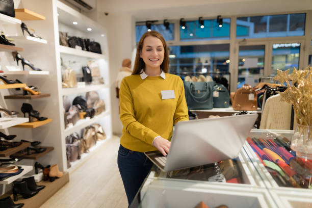 Clothing and shoe store manager using a laptop stock photo