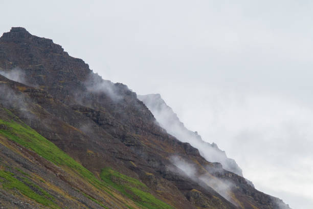 Cloudy mountain tops in the Icelandic westfjords with an overcast sky in the background. stock photo