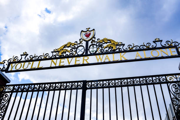 pochmurne niebo nad bill shankly memorial gates na stadionie anfield w liverpoolu. bramy mają swoje słynne hasło, "you'll never walk alone", na górze. - liverpool zdjęcia i obrazy z banku zdjęć