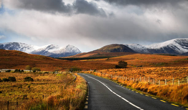 Cloudy sky and road to the mountains in Connemara Cloudy sky and road to the mountains in Connemara, County Galway, Ireland wild atlantic way stock pictures, royalty-free photos & images