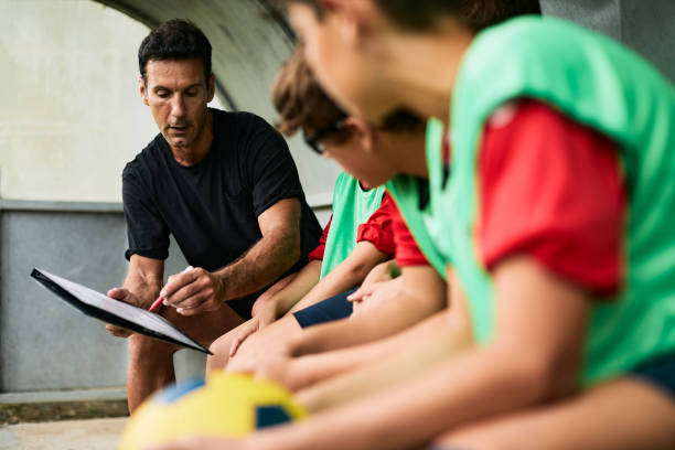 Coach explaining the game plan Lifestyle children training and playing soccer.
Coach explaining the game plan and strategy on a clipboard. coach stock pictures, royalty-free photos & images