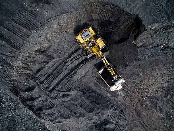 Coal mining on open pit Top view of an excavator loading the truck with coal coal mine stock pictures, royalty-free photos & images