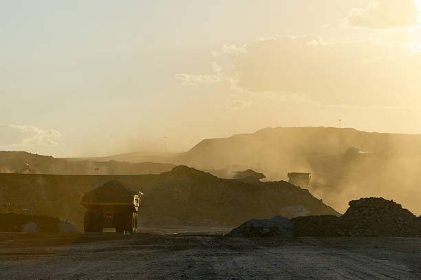 Coal mining truck hauling dirt on a hazy day Trucks on mine haul road. coal mine stock pictures, royalty-free photos & images