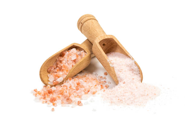 Coarse and fine Himalayan salt on wooden shovels isolated stock photo
