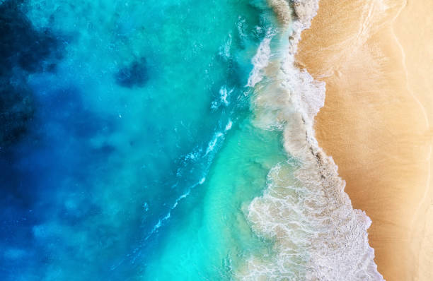 Coast and waves as a background from top view. Turquoise water background from top view. Summer seascape from air. Travel - image stock photo