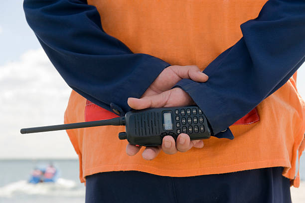 A coast guard on duty holding a walkie-talkie stock photo