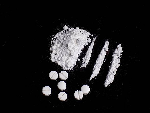 Cocaine drug powder pile and lines, pills on black background Cocaine drug powder pile and lines, pills on black background snorting stock pictures, royalty-free photos & images