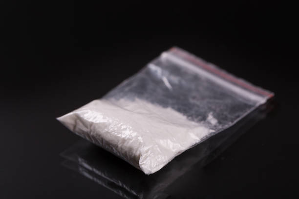Cocaine in plastic packet on black background Cocaine in plastic packet on black background, closeup amphetamine stock pictures, royalty-free photos & images