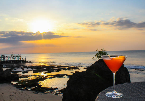 Cocktail at sunset on Jimbaran Beach in Bali, Indonesia  jimbaran beach stock pictures, royalty-free photos & images