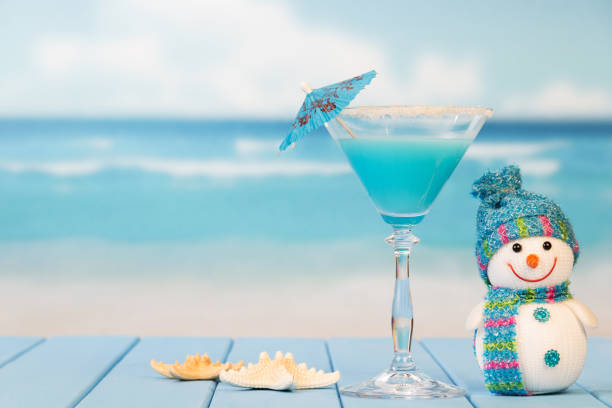 Cocktail with umbrella, snowman and starfish on the background of sea. stock photo
