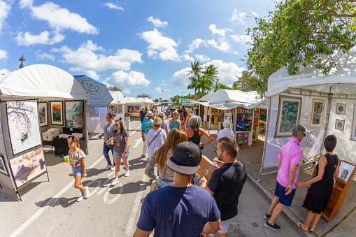 Miami, Florida, USA - February 21, 2022: Nationals and Internationals tourists and Collectors enjoying President's Day National Holidays at Coconut Art Festival; looking to buy some pieces of Arts in a sunny summer day at Regatta Park in Coconut Grove's neighborhood.