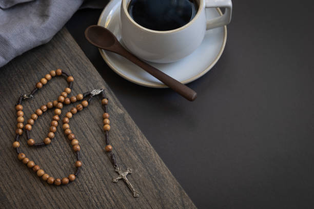 Coffee and wood rosary on black stock photo