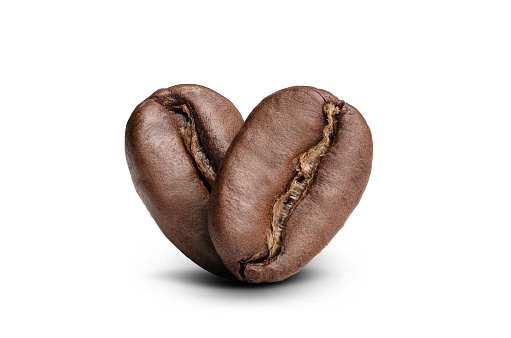 roasted aromatic coffee beans on a white background, located one after another and forming a heart shape. love coffee logo concept. studio macro photography
