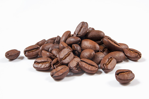 Heap of coffee beans isolated on white.