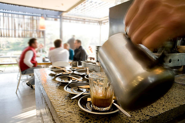 coffee being made at cafe with people in background stock photo
