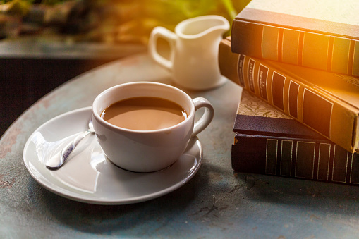 Coffee Cup and books on a wooden table