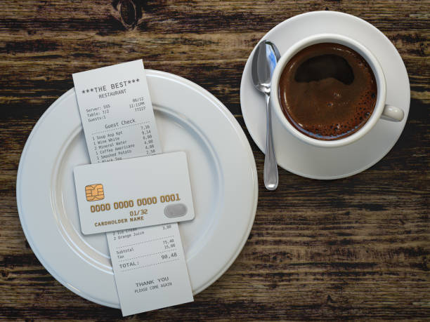Coffee cup and receipt bill for payment by credit card on wooden table. stock photo