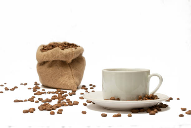 Coffee cup with beans spilled on the table stock photo