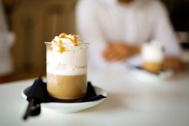 caffè decorato con sciroppo di caramello a tavola - "cafe macchiato" foto e immagini stock