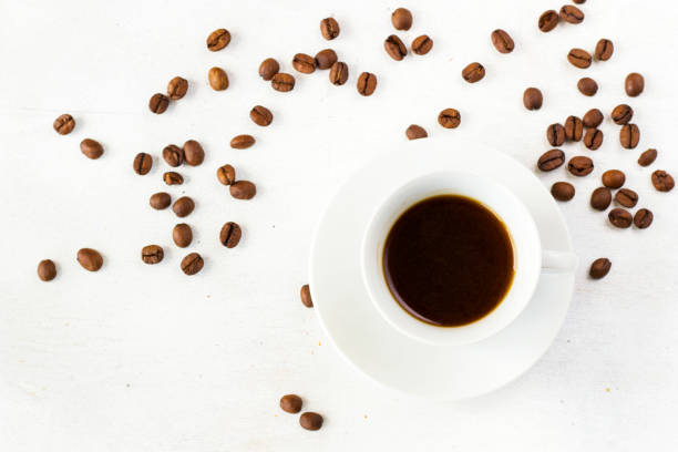 Coffee espresso in the cup on the white background and coffee beans stock photo
