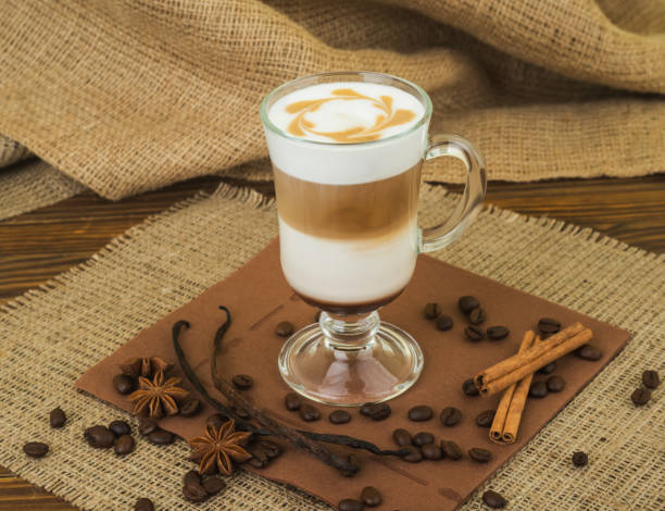caffè latte. caffè con panna montata che si topping in un bicchiere alto su uno sfondo di legno con tela - "cafe macchiato" foto e immagini stock
