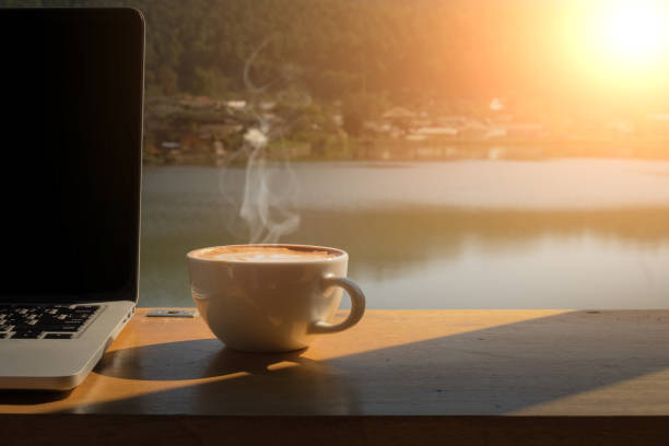 cà phê buổi sáng và máy tính xách tay trên bàn gỗ với hồ, moutian và nền làng. - coffee hình ảnh sẵn có, bức ảnh & hình ảnh trả phí bản quyền một lần