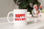 istock Coffee mug with text HAPPY BOSS'S DAY in workplace background. 1312544779