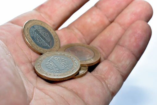 coins of a Turkish lira depreciating due to a falling course, in hand on a white background close-up