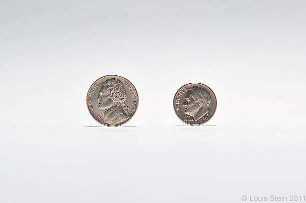 Coins on gray background US Nickel and Dime coins on a gray background  dime stock pictures, royalty-free photos & images
