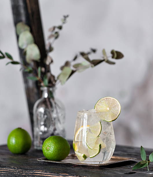 Cold cocktail with lime, lemon, tonic, vodka and ice Cold cocktail with lime, lemon, tonic, vodka and ice on vintage background vodka soda stock pictures, royalty-free photos & images