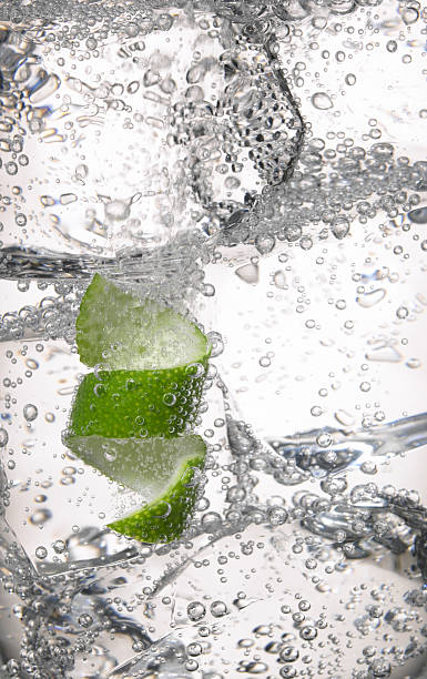 Cold drink Close up of clear cold drink, ice cubes and lime peel vodka soda stock pictures, royalty-free photos & images